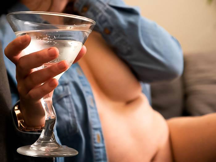 Disabled sex worker: Tasteful photo of author in nothing but a faded blue denim shirt holding a martini glass. Image for artilce about being a disabled sex worker with a chronic illness, and working as a disabled escort for the disabled.