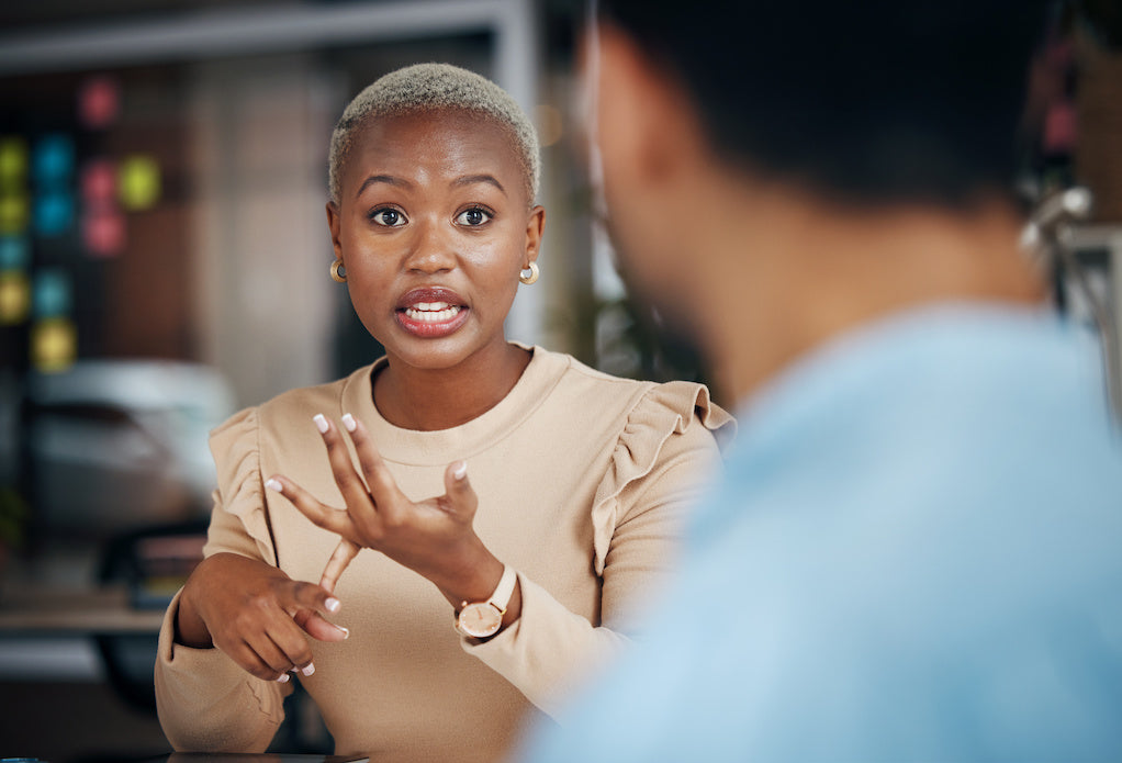 How to explain endometriosis to your boss: a Black woman is having a conversation with their male colleague.