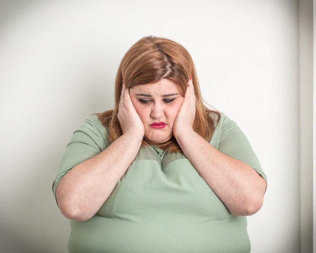 Image of a woman placing her hands over her ears in denial of the news that both parents have cancer.