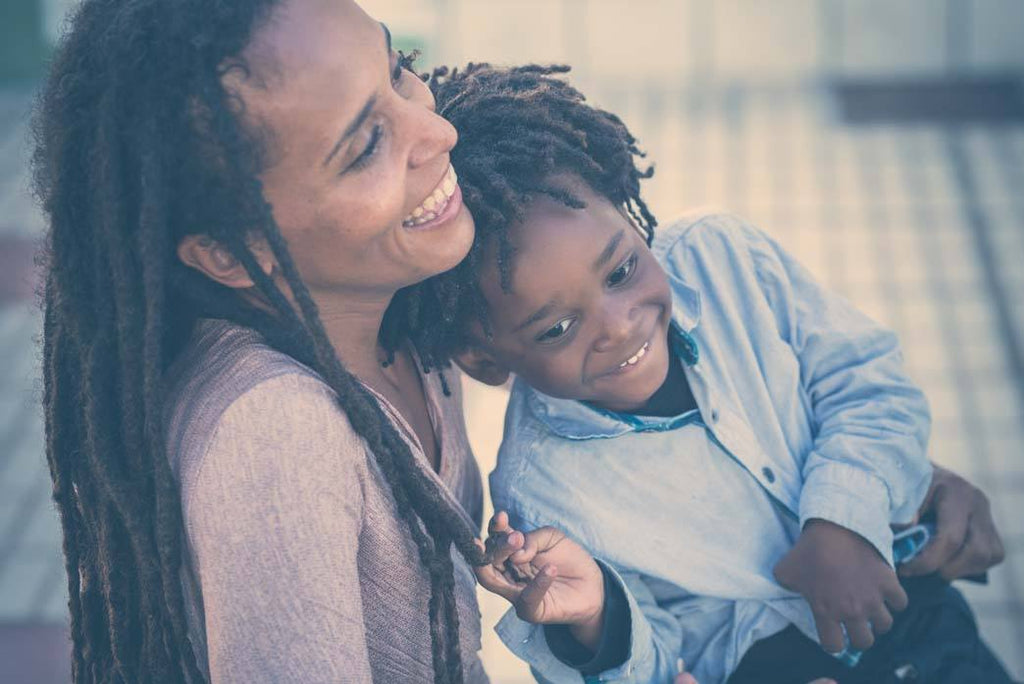 Having a baby with cerebral palsy: a photo of a Black mother and their son with dreadlocks in a tender moment