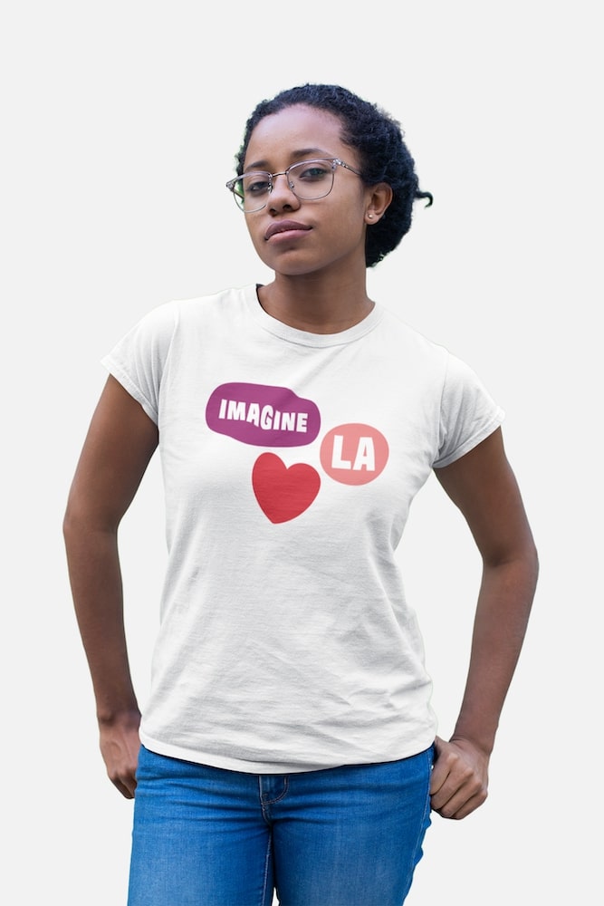 Imagine LA: a young Black woman is wearing a white t-shirt with Imagine LA logo on it.