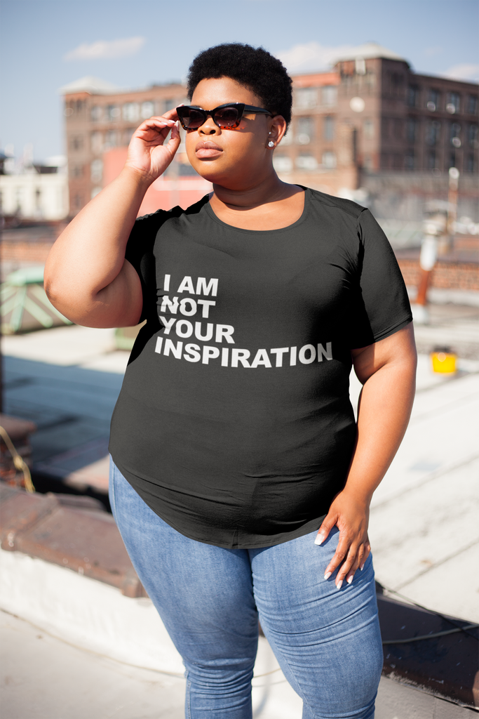 A plus size model is wearing a t-shirt with the phrase, "I am not your inspiration," printed on it.