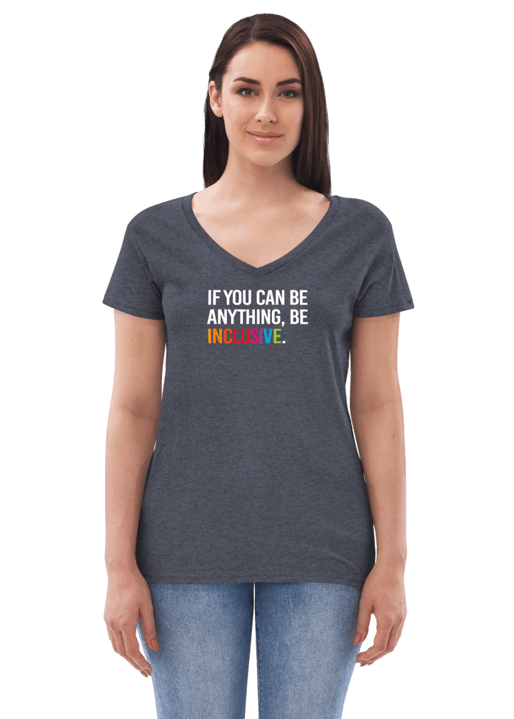This is a photo of a heathered navy Eco-Friendly Be Inclusive V-neck tee. In the top third of the tee, in white upper case letters, is the phrase, 'If you can be anything, be inclusive,' The words, be inclusive, are in the colors of the rainbow. The v-neck is worn by a model highlighting how the tee comes in at the waist and then widens over the hips.