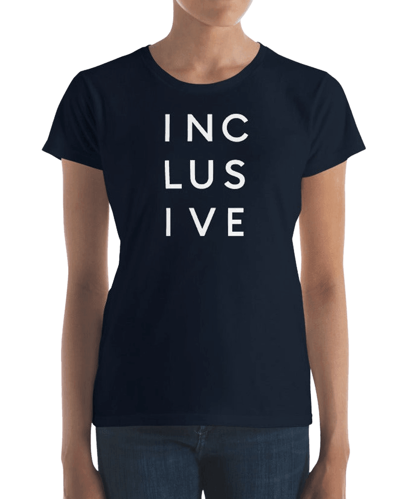 Navy women's cut inclusive t-shirt. It has the word 'inclusive' in the middle of the chest in upper case black letters over three lines, with three letters on each line: INC LUS IVE. The design takes up the top middle 1/3 of the front of the inclusive t-shirt. The t-shirt is worn by a model.