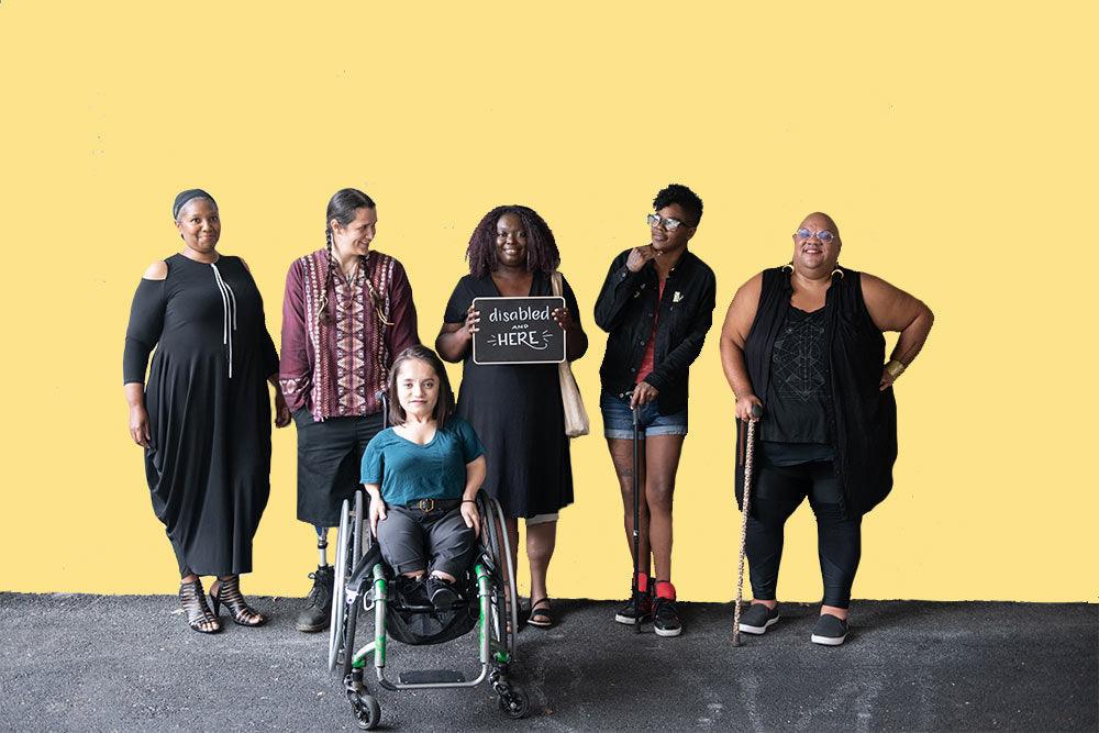 alt="Article on getting organizations ready for disabled employees: Six disabled people of color smile and pose in front of a concrete wall."