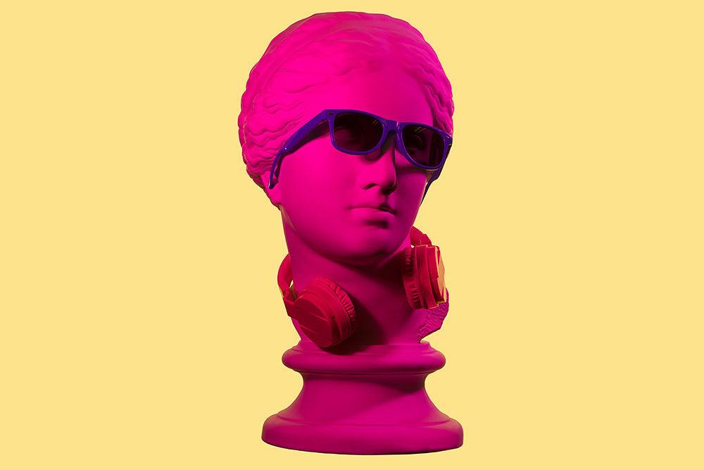 Learning to learn: ADHD and distraction. Pop art graphic of a statue of Aphrodite's head in hot pink wearing sunglasses and headphones around its neck.