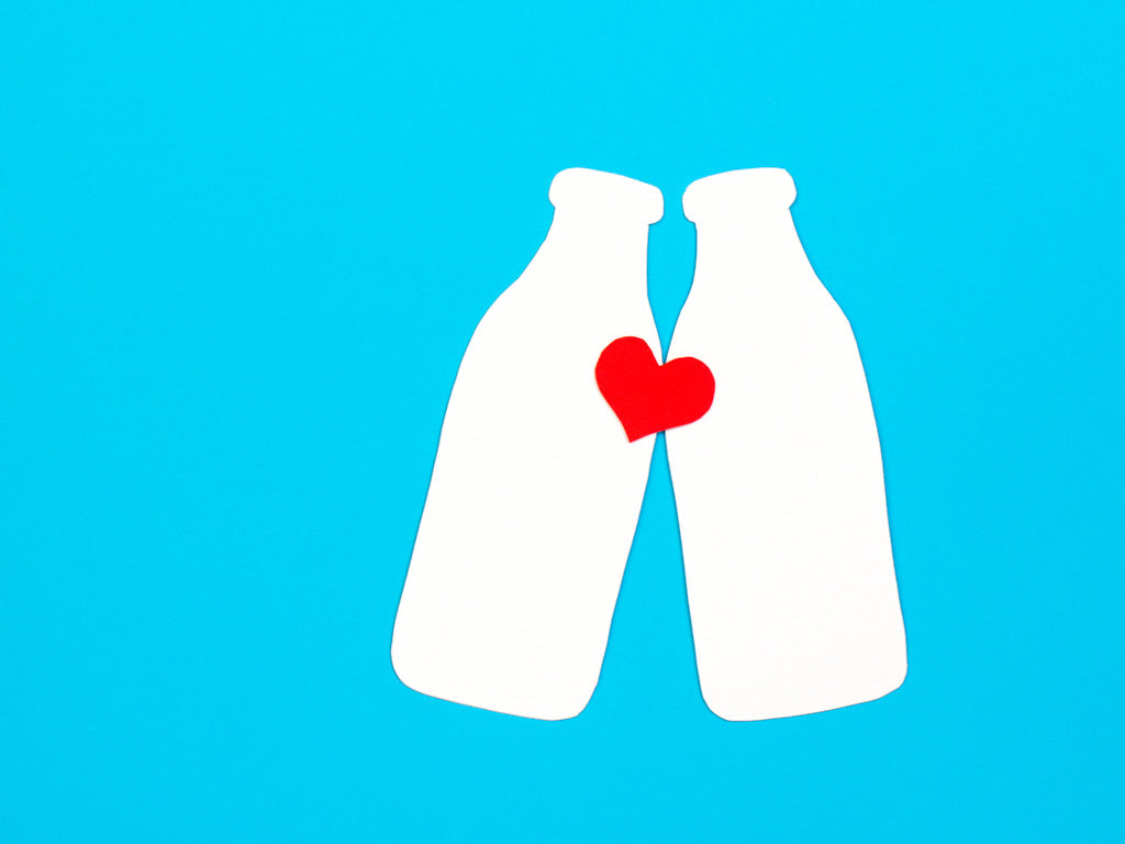 Illustration of two white healthy milk bottles with a love red heart connecting them together. Illustration for an article: 