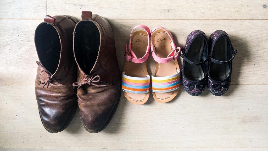 Photograph of a 'bird's eye' view of three pairs on shoes on a lime washed floor-boarded floor for an article about a dad with OCD.