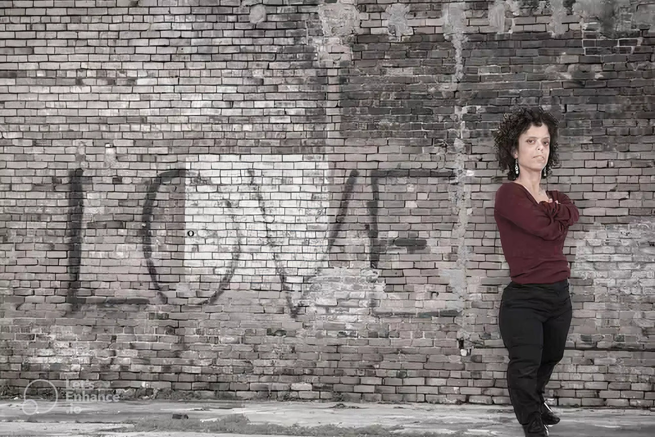 A little person is standing against a brick wall with the word LOVE painted on it,  symbolizing inclusivity and awareness of respectful language