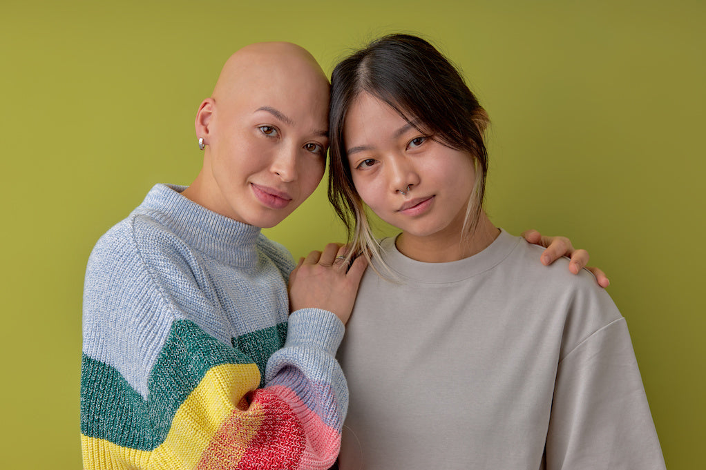 Dealing with unsupportive friends and family during cancer: two diverse women posing at camera supporting each other
