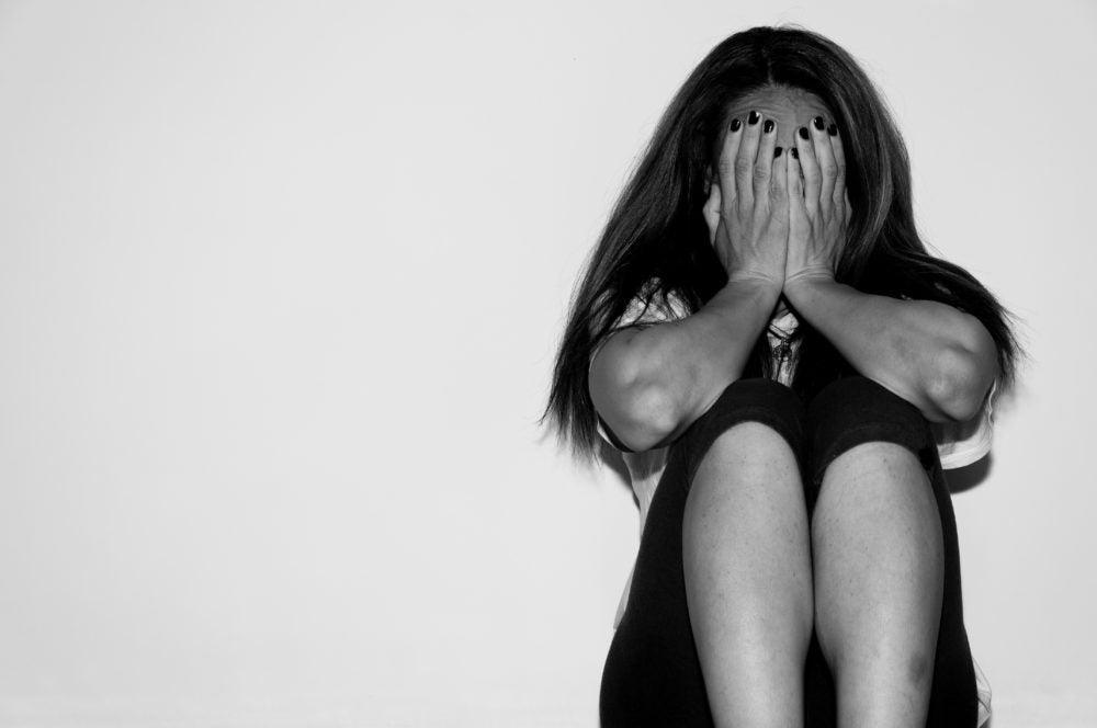Testing positive for HIV in Kenya: Crying woman abused as young feeling depressed and miserable while she sitting alone on her bed