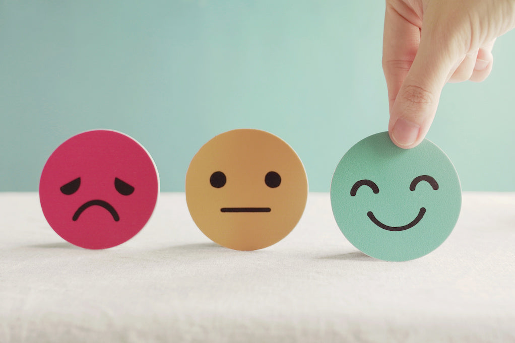 Employers need to prioritize employee mental health: a photo of a hand choosing a happy emoji 