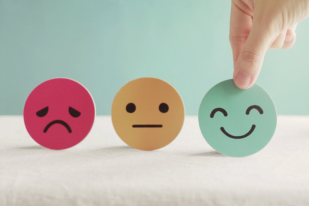 Employers need to prioritize employee mental health: a photo of a hand choosing a happy emoji 