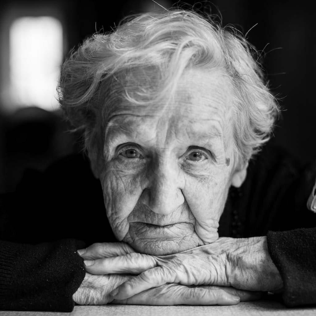 Black and white closeup portrait of an elderly woman thinking of rational suicide.