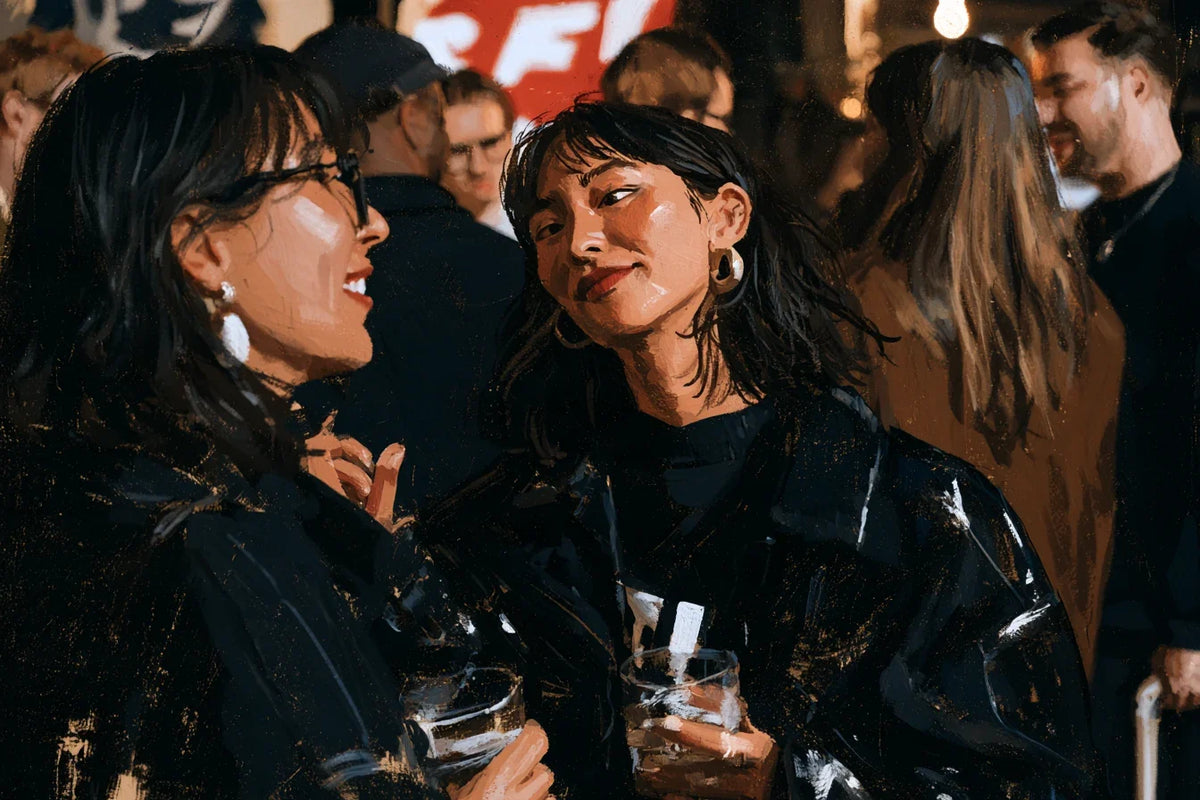 Two adults talking at a crowded social gathering, one giving the other a wry sideways look.