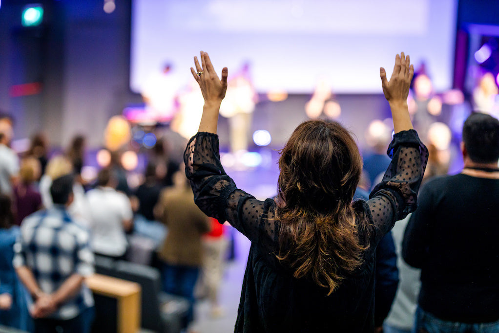 A story about glaucoma: feeling the anointing. A color photo of a congregation praying together. 