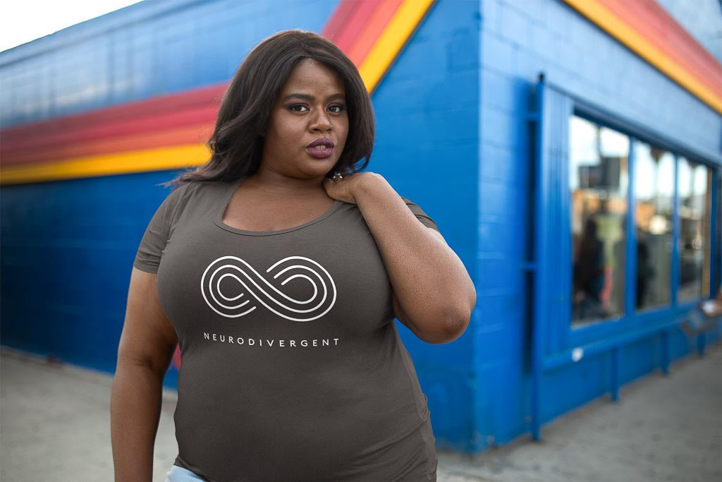 Has the diagnosis of autism changed: a Black woman is standing outside wearing a neurodivergent shirt with a large white infinity symbol.