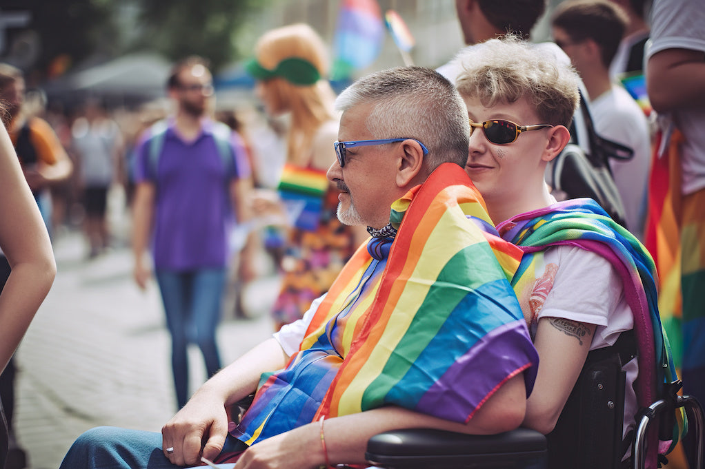How to make pride more inclusive of disability: two people are at a parade draped in pride flags. One of them is a wheelchair user.