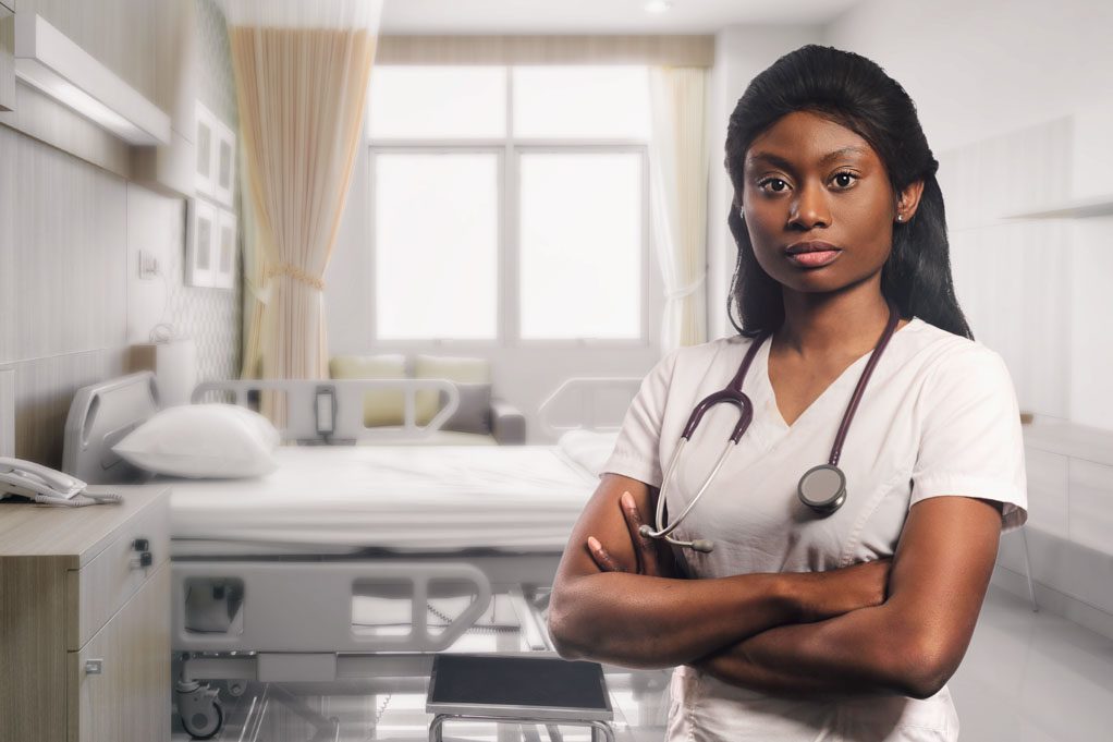 How to identify racism in health care. Image of a young black doctor staring intently at the camera in an empty hospital ward.