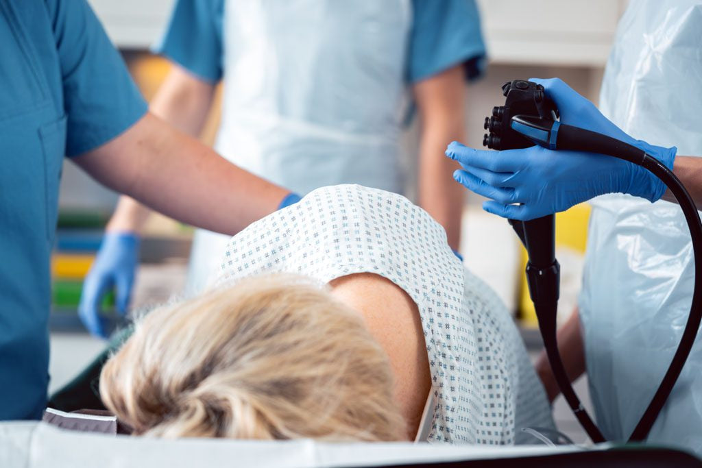 Patient and doctor in hospital operating room. The patient is having a colonoscopy and endoscopy at the same time.
