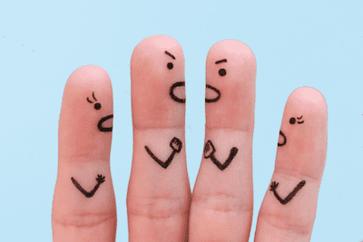 For article on Ehlers-Danlos sex. A shot of four fingers seen from finger tips to the middle finger joints (nails are not seen as the hand is facing the other direction). Each finger has a face and arm drawn in pen.