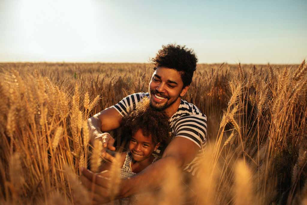 Portrait of a single dad disabled daughter having a good time in a wheat fields in the late afternoon.