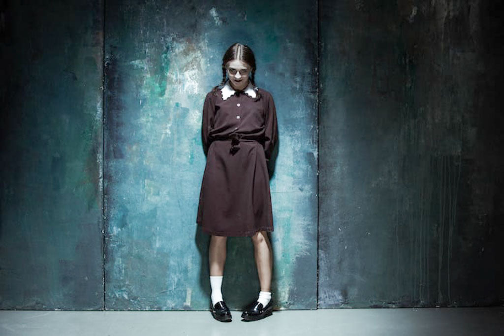 Depictions of schizophrenia in media are like this dark portrait of a person dressed as a school girl with an evil grin.
