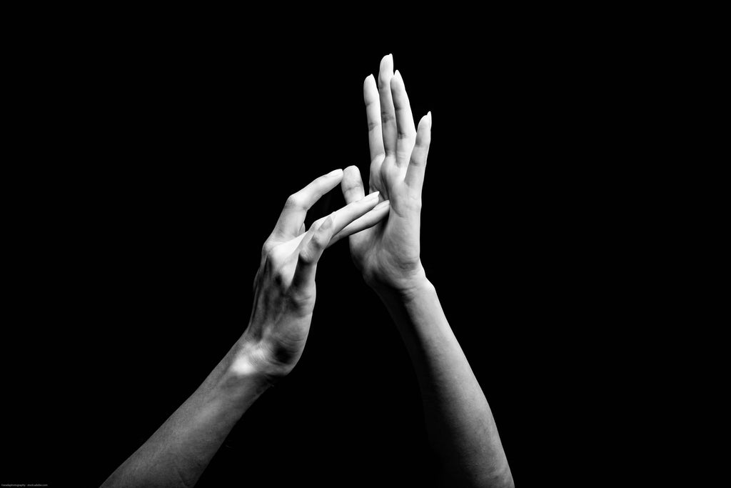 Image for article on Deaf Christian Church. A black and white photo of the American Sign Language for “Jesus.” The tip of the middle finger of the dominant hand is placed in the center of the palm of the non-dominant hand. 