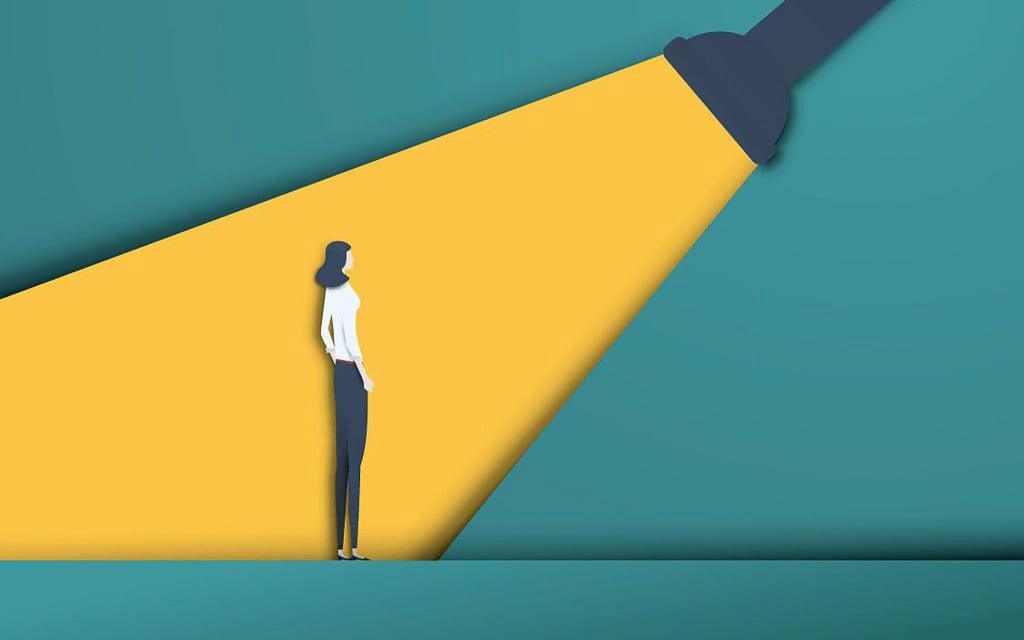 Living with Tourette Syndrome: a paper collage of a person standing in the middle of a bright yellow spotlight, which is an analogy for what it is like living with Tourette Syndrome