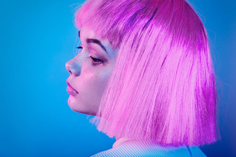 How to help someone with fibromyalgia: upclose shot of a person in a purple wig looking miserable. Image for article on how to help someone with fibromyalgia.