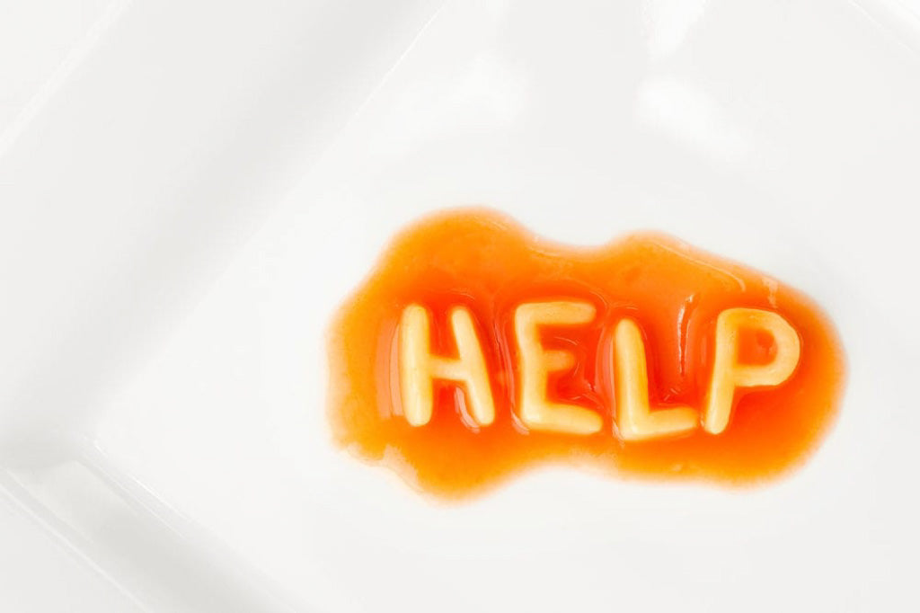 A help message written in pasta letters on square white plate. image for the article:lara's eating disorder horror stories: one about almonds.
