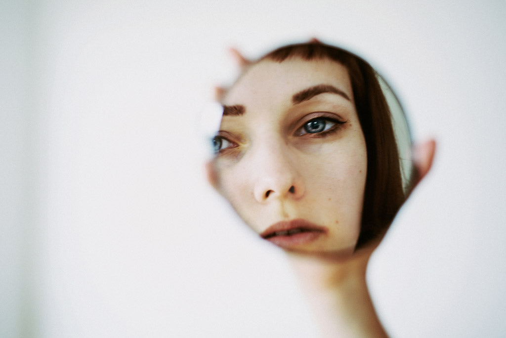 A woman with an eating disorder stares at a mirror reflecting on her use of pro ana sites.