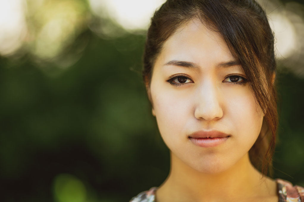 Celiac diagnosis stories- a close up photo of a sad asian person after diagnosis of celiac disease.