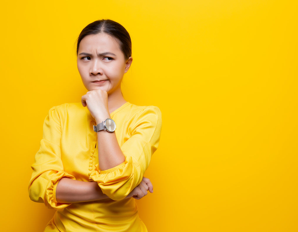 She's wearing a bright yellow blouse and is photographed against a bright yellow background.