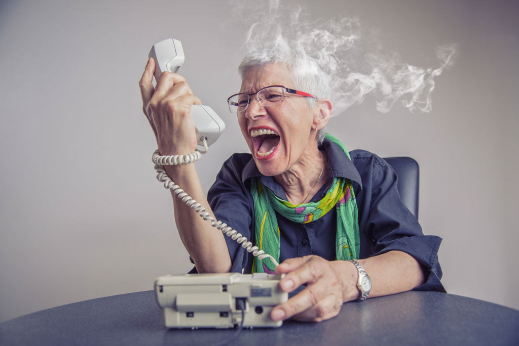Image of an older woman with smoke coming out of head creaming at the phone. Image for article: my mom has breast cancer what can I do