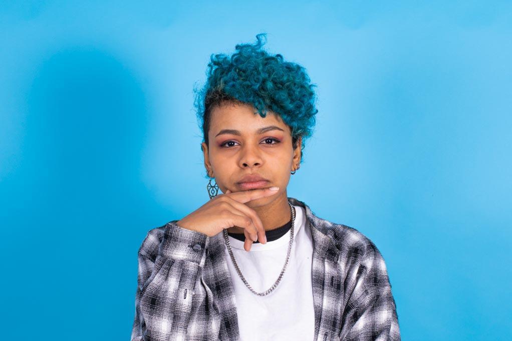 Anxiety and depression is real: photo of a a trendy afro american young woman isolated on a blue color background