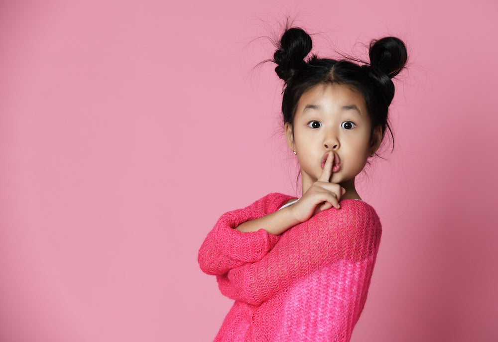 Photo for article on building communication skills of Autistic children. Young child with their hair in two 