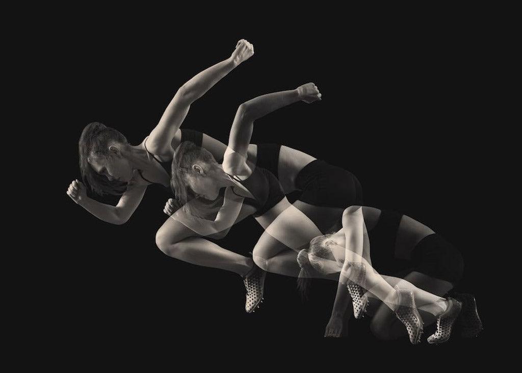 Artistic black and white photo of sprinter leaving starting blocks with a triple exposure effect. Photo for an article on running with anxiety and depression