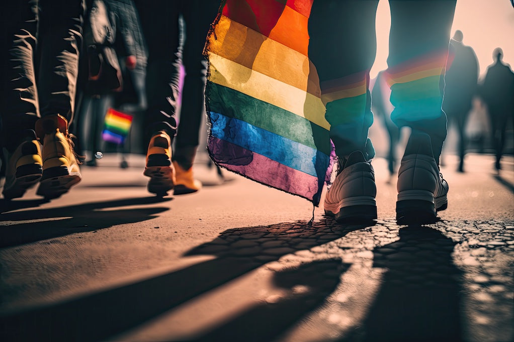 An AI generate image of the feet of people marching at Pride against LGBT bias in healthcare