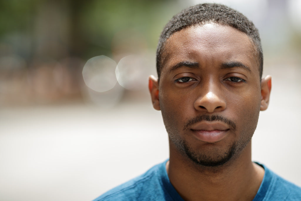 A portrait photo of a young man living with early onset Parkinson’s disease