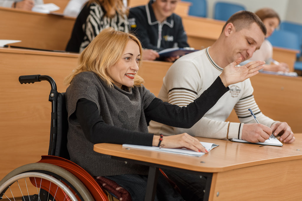 Managing chronic illness at college includes accessing accommodations: a photo of a student in a wheelchair attending a college lecture.