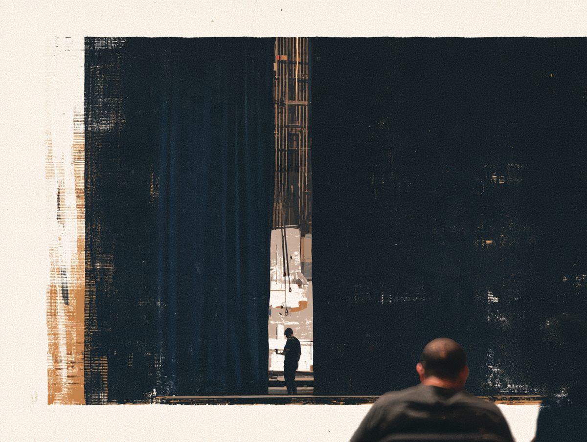 A seated viewer faces dark theatre curtains, with a standing figure and stage rigging visible through a narrow opening.