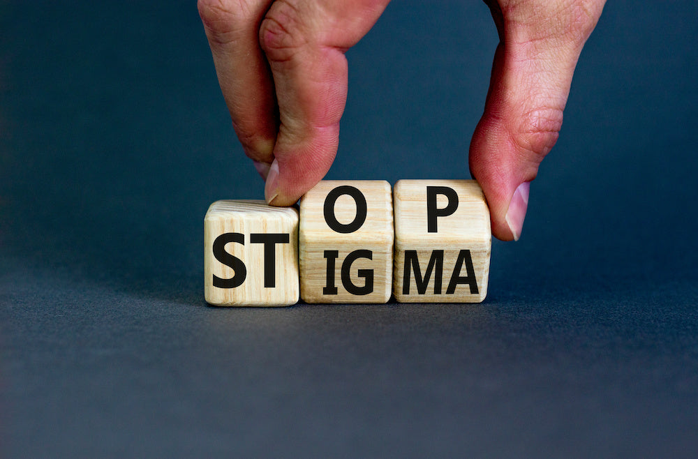 Police culture and mental health: a photo of three wooden cubes that read "STOP STIGMA"