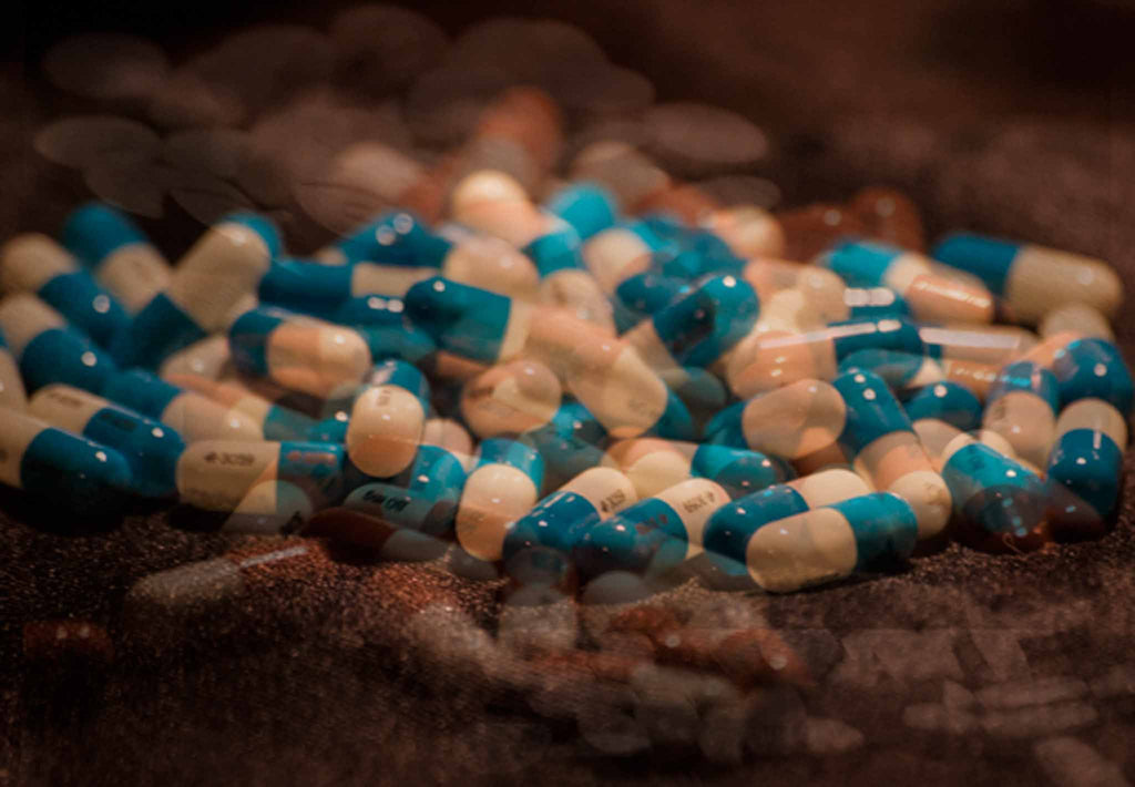 This image is a blurred photo of blue and white pills illustrating how someone might feel taking antipsychotic drugs. d