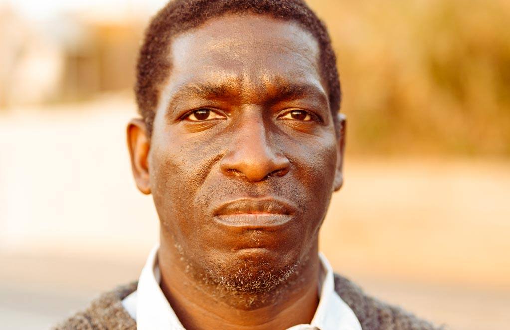 Portrait of a mature African man in a warm sweater in park. Photo for article: Vicarious trauma changed my personality