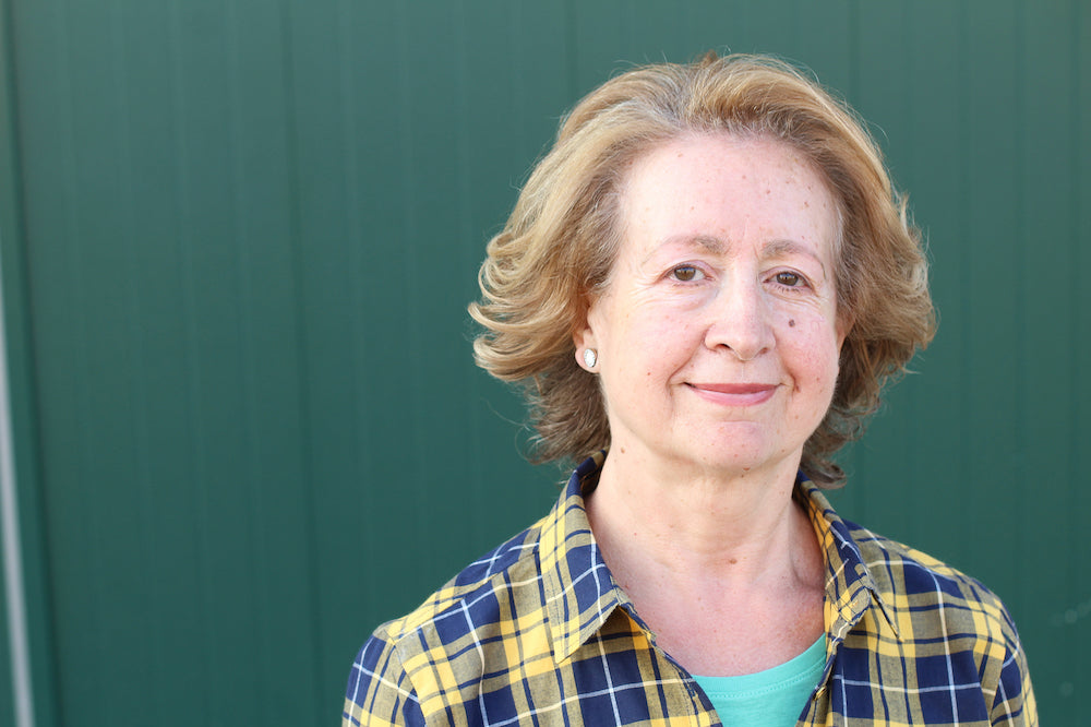 What is ketamine treatment for migraine like: a photo of a middle-aged woman with short cropped red hair standing against a green wall