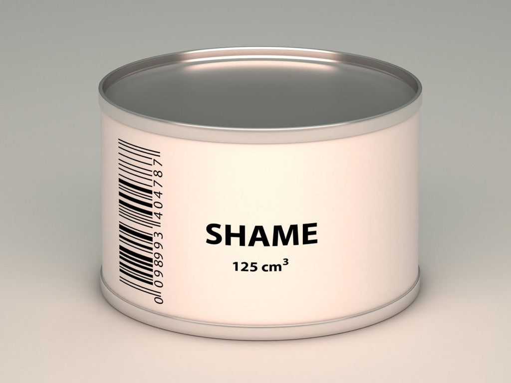 this is a photo of a small tin with a white label set against a plain background. The label has the word 'shame,' on it typed in large black upper case letters