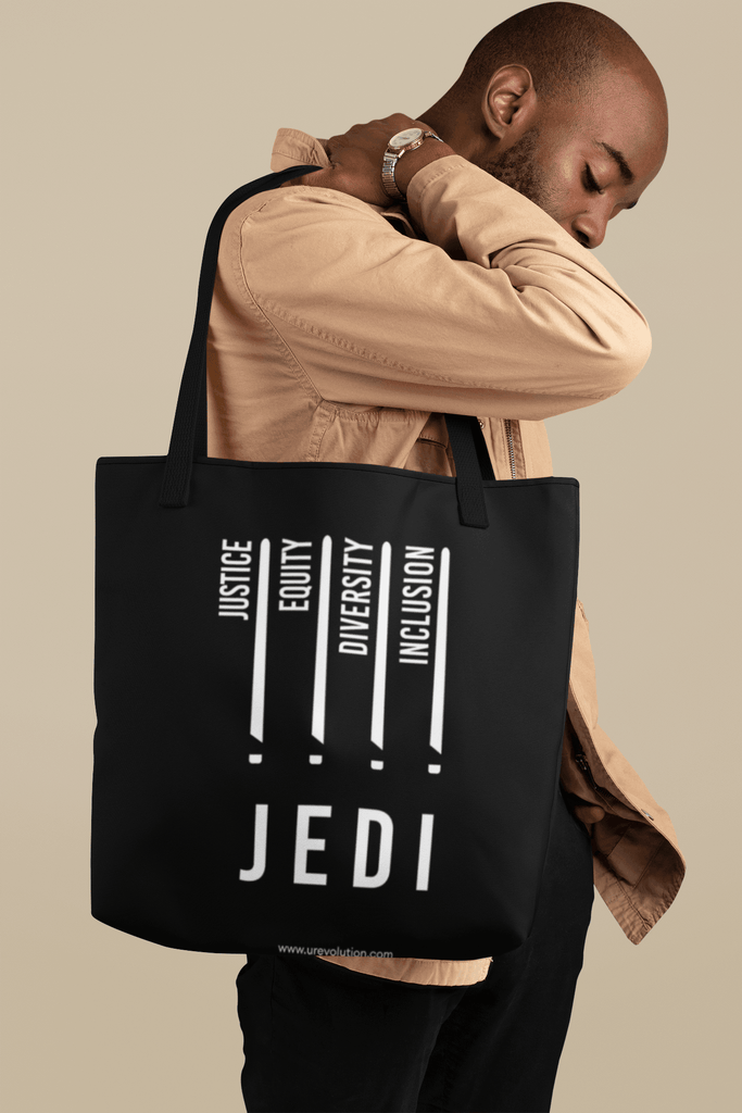 JEDI Inclusion: a tall person is holding a black JEDI tote bag with a white JEDI justice equity diversity inclusion design.