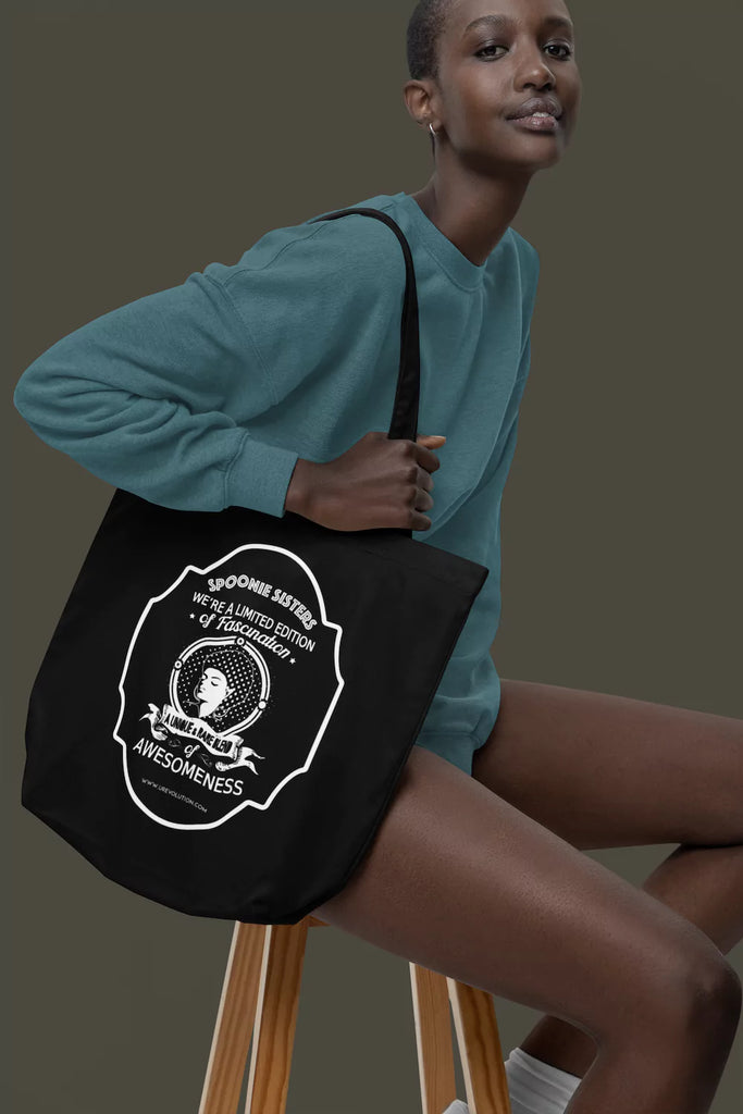 Black model holding the Spoonie Tote Bag, showcasing the stylish and eco-friendly organic cotton tote for Spoonies and disability advocates.