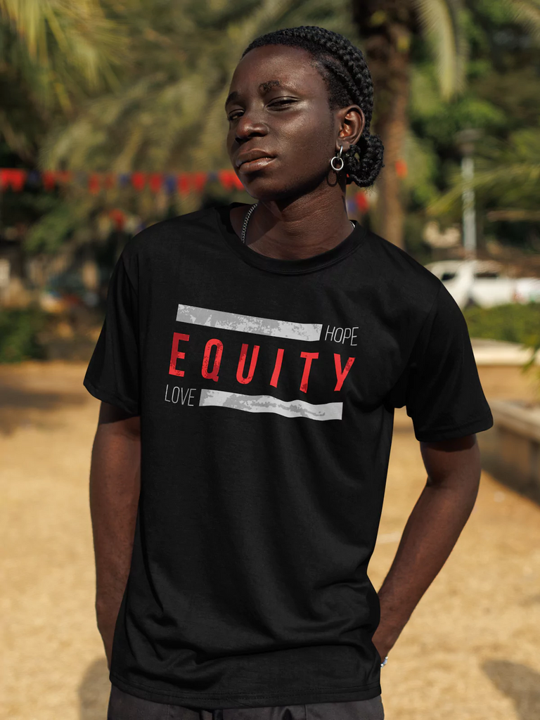 Black man wearing an Equity T-shirt that says "Hope Equity Love" in an outdoor setting with palm trees and red bunting in the background.